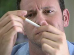 Man looking at cigarette and snapping it Stock Footage