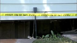 Yellow tape is strung as a safety measure beside a flood damaged building. Stock Footage