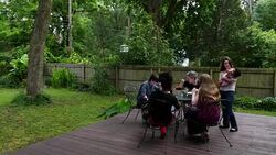 MS Family eating birthday cake on backyard patio of home on summer evening Stock Footage