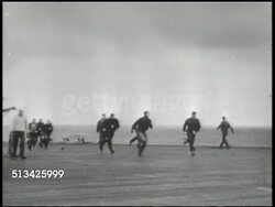 1940s: UNITED STATES NAVY:  VS Grumman F6F Hellcat (landing gear not down) coming in for a crash landing on U.S. Navy carrier, crew running out, helping wounded pilot out of cockpit into stretcher, plane falling off deck into water, sea, ocean. WWII Instructional Video