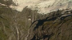 A waterfall pours over a glacial cliff. Stock Footage