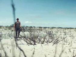 Backpacker walking through the desert Stock Footage