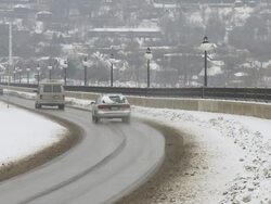 MS Cars passing over bridge in Saint Paul through fresh white snow and dirty brown snow / Saint Paul, Minnesota, United States  Stock Footage