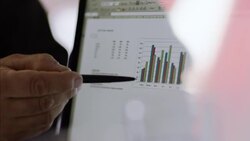 Financial advisor points out bar graph results on laptop computer Stock Footage