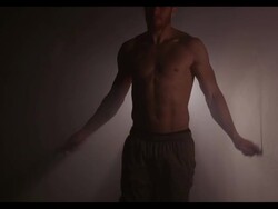 A slow motion clip of a shirtless male athlete doing a jump rope exercise. Stock Footage