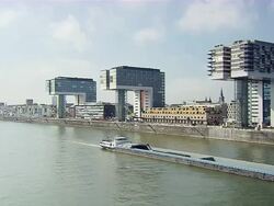 WS Transport ship moving in front of three Cranehouses and buildings in city / Cologne, North Rhine-Westphalia, Germany Stock Footage