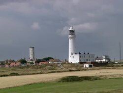 Aerial lighthouse and chalk tower on Flamborough Head / seabirds flying along chalk cliffs / England Stock Footage