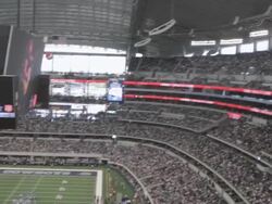  PAN Video screen playing music as fans crowd the stands at Cowboys Stadium / Arlington, Texas, United States Stock Footage