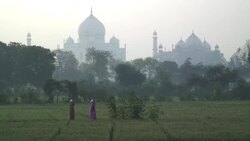 Women in saris carry water past the Taj Mahal in Agra, India during the golden hour. Stock Footage