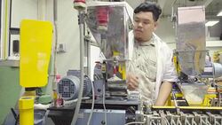 dolly: big engineer is looking into extruder Stock Footage