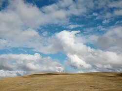 WS T/L View of Dramatic puffy clouds boiling over golden prairie hills / White Sulphur Springs, Montana, United States Stock Footage