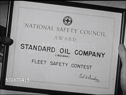 1947: STANDARD OIL (INDIANA): DELIVERY TRUCK: HA Following 'Standard' Oil (Indiana) gas delivery tank truck moving up road in rural neighborhood. MS Driver in uniform, shirt, bow tie & cap, driving truck.  Petroleum, fossil fuel, energy, consumer. Instructional Video
