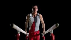 SLO MO Gymnast doing L-sit on parallel bars Stock Footage