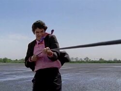 Low angle medium shot businessman holding on to rope and being pulled towards CAM / wind blowing in his face Stock Footage