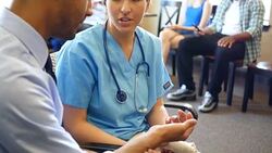 Hispanic triage nurse talks with patient about injury Stock Footage