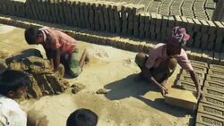 Young men in Bangladesh use simple wooden moulds to fashion bricks from a simple clay and water mix there actions are fast and rhythmical  Stock Footage