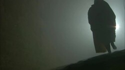 A barefoot man in a galabiya steps across a rough surface toward a light in Cairo, Egypt. Stock Footage