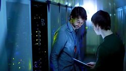 Server room technicians using digital tablet at server panel Stock Footage