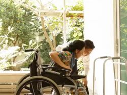 young caregiver helping elderly woman on wheelchair Stock Footage