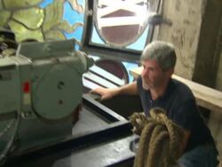 A man scales a ladder and oils the gears of a clock with an oil can. Stock Footage