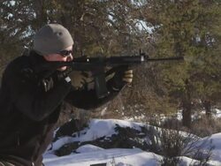 CU SLO MO Shot of man shoots  AR-15 rifle in winter wood landscape / Bend, Oregon, United States  Stock Footage