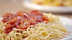 SLO MO sprinkling parmesan over spaghetti with tomato sauce Stock Footage
