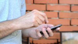 Man types text message on his smartphone Stock Footage