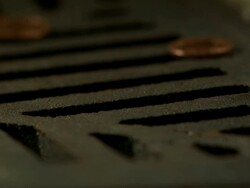 Money Down the Drain - High speed English coin, 10p, with British Lions design, falling on and rolling in to road drain, low angle 6 BCU Stock Footage