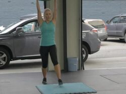 Medium shot. Carly performs overhead lunge. Stock Footage