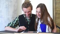 Happy couple with tablet computer sitting in cafe Stock Footage