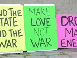 Pan of anti-war protest signs at rally. Stock Footage