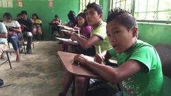 Wide-angle shot of Kichwa Indian elementary school students taking final exam at rudimentary school in autonomous indigenous region of Sarayaku in the Ecuadorian Amazon Stock Footage
