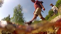 POV from creek to middle aged couple crossing the stream Stock Footage