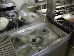 Woman drops fresh pasta into a boiler in a restaurant Stock Footage