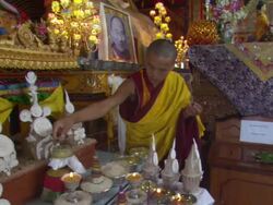 MS Monk setting spool of string on shrine in Kopan monastery / Kathmandu, Central, Nepal Stock Footage