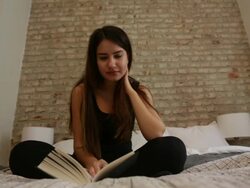 Young Woman Sitting on her Bed Reading Stock Footage