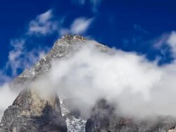 Panning shot of Time-lapse of clouds swirling around a Himalayan peak. Stock Footage