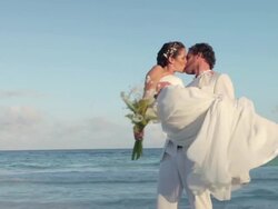 Newlyweds on beach, groom lifting up bride and spinning her round Stock Footage
