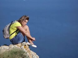 Young woman resting on a mountain coast Stock Footage