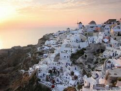  Domed white washed churches of Oia at Sunset with a view overlooking the Aegean Sea on the Island of Santorini, Greece, Europe Stock Footage