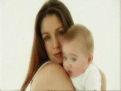 CU mother and baby playing on cushions, baby vomits downs mothers arm Stock Footage