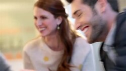 Creative young business people write and laugh around white-board table in large corporate office common area Stock Footage