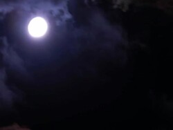 Spooky moon between passing clouds Stock Footage