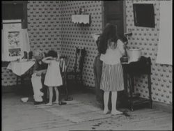 Children wash up for breakfast as a mother prepares the meal. News Clip