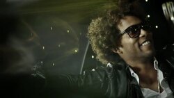 Hip-hop star nods and waves to fans from back of limousine at awards show Stock Footage