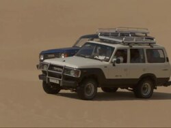 Medium, tracking-left - Two vehicles travel across the Sahara Desert in Egypt Stock Footage
