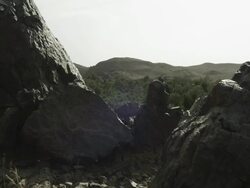 Large rocks jut out of the landscape, and frame the hills beyond them. Stock Footage