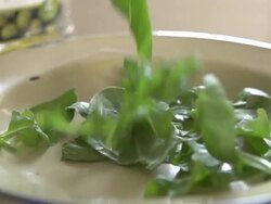 Spinach leaves dropped into bowl Stock Footage