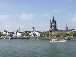 MS Shot of Cologne Cathedral at Old City and boat moving under train bridge with Blue sky / Cologne, North Rhine-Westphalia, Germany Stock Footage