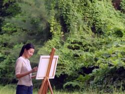 WS Asian woman painting in a forest. Stock Footage